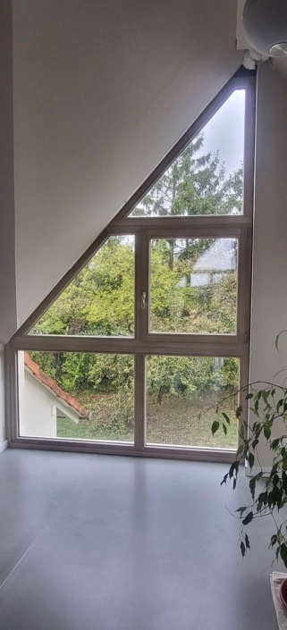 Grande baie triangulaire en mélèze triple vitrage, vue intérieure de face