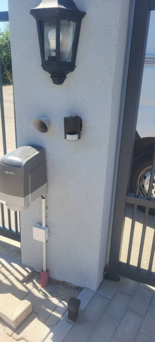 Moteur Somfy io à bras articulé fixé sur le pilier du portail battant en aluminium anthracite