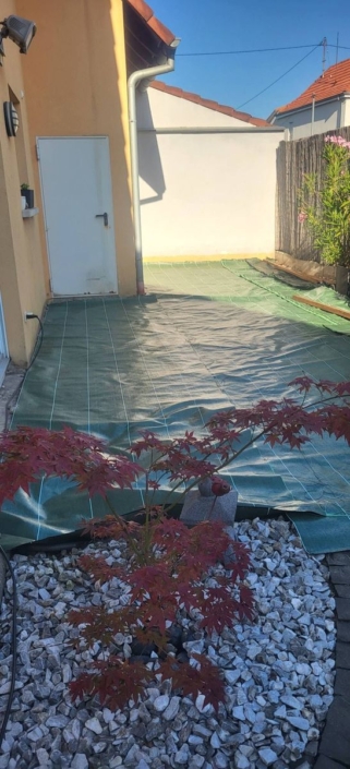 réalisation d’une terrasse en mélèze du Canada avec fixation invisible Sol stabilisé et recouvert d'une toile géotextile avant la pose de la nouvelle terrasse