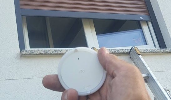 Volet roulant solaire Somfy à lames teinte bois et sa commande radio io, posé par HRV Menuiserie (Betschdorf)