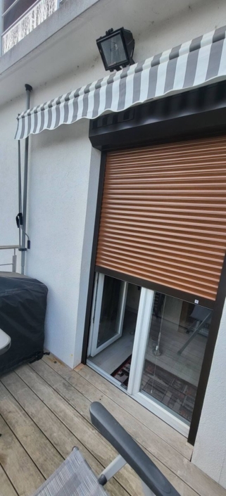 Volet roulant solaire à coffre anthracite posé en rénovation sur une porte-fenêtre donnant sur une terrasse